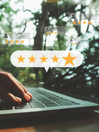 Person on laptop leaving a 5 Eli Moore Google review