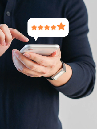 Person holding smart phone and leaving a 5 Eli Moore Google review