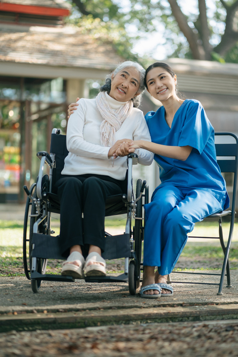 Two women sitting in front of a building.